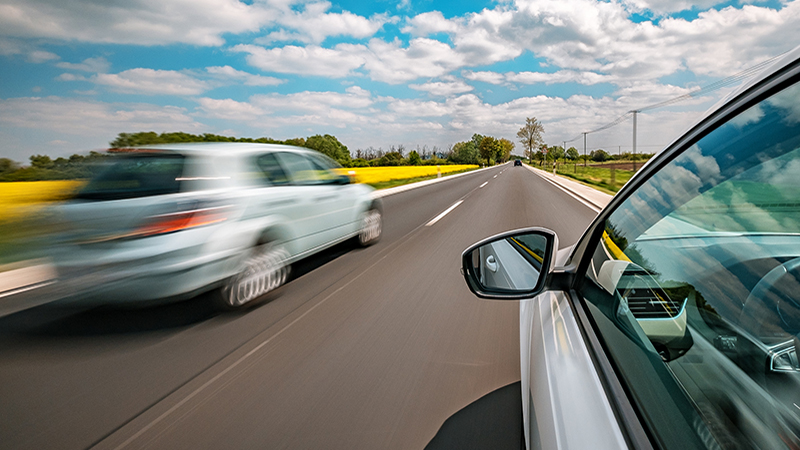Driving on a beautiful spring day. Car overtakes another car on the road